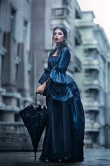 Fototapeta premium Outdoors portrait of a victorian lady in blue