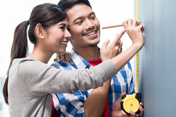 Young indonesian couple, woman and man, doing home improvement in their new residence