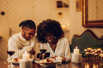 African american couple having romantic date and drinking wine at home