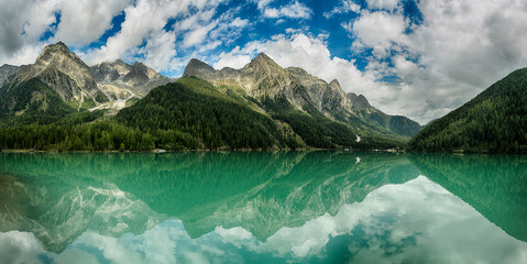 Lake of Anterselva surrounded by mountains with blue sky and clouds in the background on a summer day, Sud Tirol, Italy