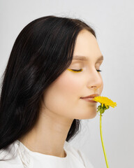 Happy smiling woman with yellow flowers in their hands - Closeup of yellow flowers, on focus