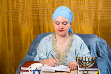 Jewish woman in headdress kisui rosh tradition teacher takes notes for lectures.
