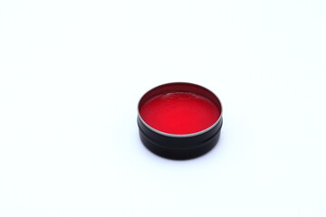 Red lip balm and a white background.