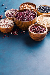 Assortment of beans on a blue background. Background wiht copyspace.