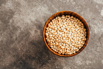 White beans in a wooden bowl on a gray background