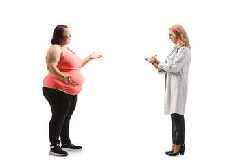 Full length profile shot of an overweight woman talking to a female doctor
