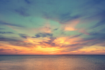 Fototapeta na wymiar Aerial panoramic view of sunset over ocean. Nothing but sky, clouds and water. Dramatic picturesque evening scene. Ocean and colorful cloudy sky in the background. Nature landscape. Travel background
