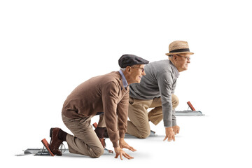 Full length profile shot of an elderly men kneeling on starting blocks preparing for a run
