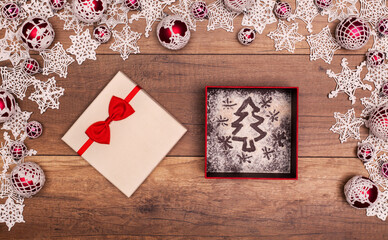 Fototapeta na wymiar Christmas tree and stars in a gift box - inside seasonal decorations frame on wooden table