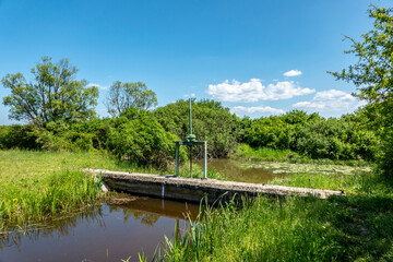 A water channel in the swamps with a dam to regulate the amount