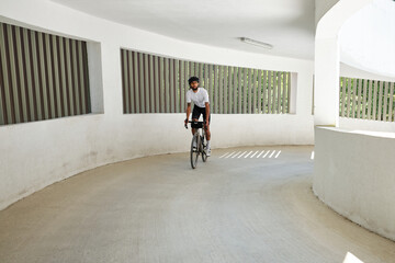 Professional cyclist riding on an empty city parking lot.Sports motivation