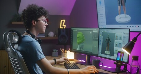 Young 3D designer creates video game character or clothes, works remotely from home on computer and big digital screen with professional software interface and tools for 3D modeling and design.