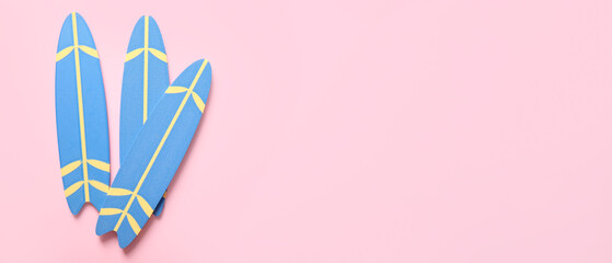 Blue surfboards on pink background with space for text