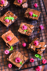 Brownie squares decorated with fresh raspberry and mint leaves