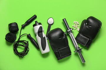 Composition with sports equipment, bottle of water and amino acid supplements on green background