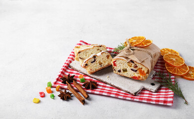 Christmas Stollen, sliced on red napkin with spices and decor. Homemade Traditional Cake.