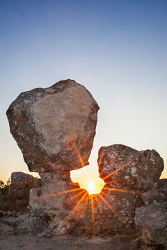 Sun rising between megalithic monument of Cancho Que Se Menea. In English shifting rock. Montanchez, Spain