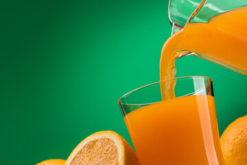 Pouring orange juice into a glass and sliced fresh oranges, vitamins and healthy drinks concept