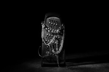 Grater with silver jewelry on black background