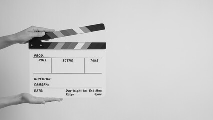 The hand is hold a clapper board or movie slate.on white background.In black and white picture.