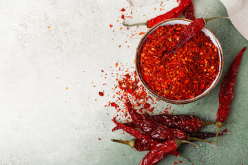 Bowl of ground peppers with dry hot chili on light background - obrazy, fototapety, plakaty