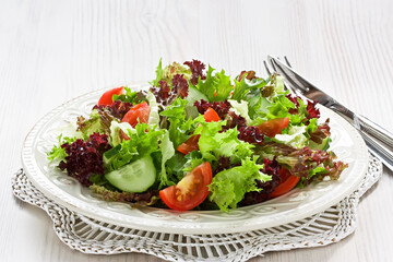 Fresh salad with green, red lettuce, tomato and cucumber