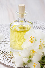 Essential oil with jasmine flower on wooden background