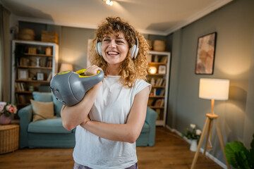 portrait of caucasian adult woman stand at home hold kettlebell girya