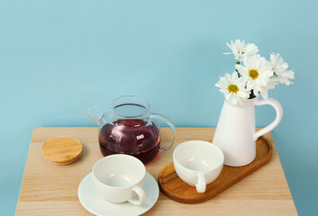 Beautiful tea set with flowers on wooden table