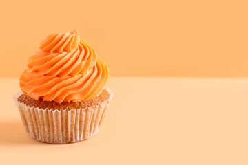 Tasty cupcake on orange background