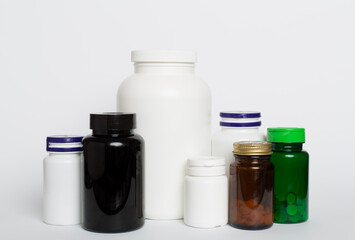 Plastic bottles for vitamins on color background