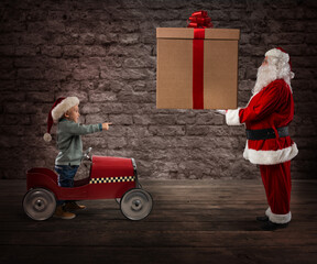 Amazed child watch Santa Claus who gives him the CHristmas gift
