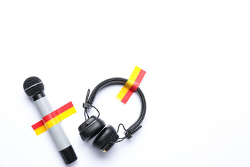 Microphone with headphones and adhesive tapes on white background