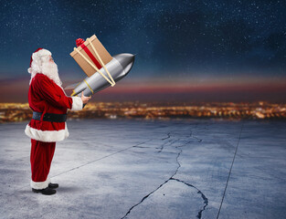 Santa Claus ready to to launch a rocket with Christmas gift box in the sky