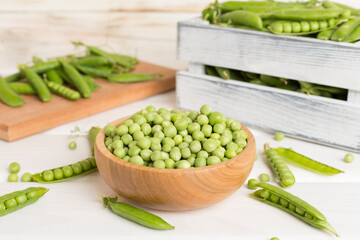 Composition with fresh green peas on wooden table