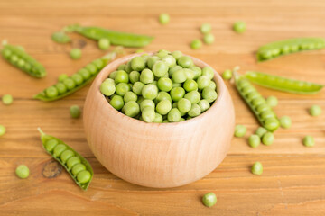 Composition with fresh green peas on wooden table