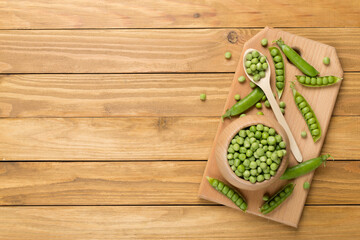 Composition with fresh green peas on wooden background, top view