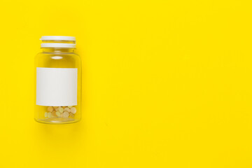 Plastic bottle with vitamins on color background, top view