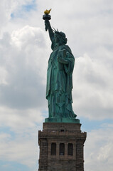 Fototapeta na wymiar The Statue of Liberty on Liberty Island under cloudy sunny skies