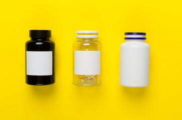 Plastic bottles with vitamins on color background, top view