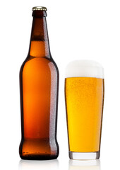 Cold bottle and glass of lager beer with foam and dew isolated on white background