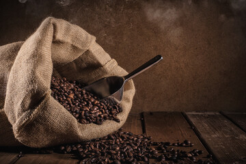 Coffee beans with jute bag and bailer on grunge background