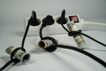 Fototapeta trzy kable elektryczne podłączone do rozdzielacza. Banknoty zawiązane na każdym kablu. Koncepcja oszczędzania energii. obraz
