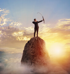 Businessman with bow on top of a mountain