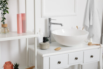 Sink bowl with bath accessories on table in bathroom