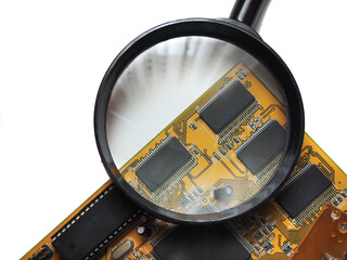 Digital circuit board and blank chips under magnifying glass on a white background.