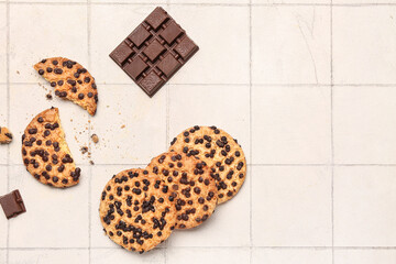 Cookies and chocolate on white tile background