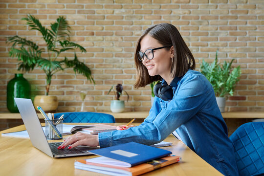 Young Female University Student Studying At Home, Using Laptop