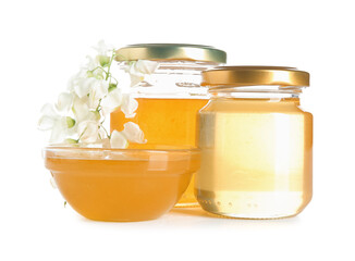 Jars and bowl of honey with flowers of acacia on white background