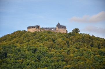 Fototapeta na wymiar View of the fortress Waldeck on a mountain at the Edersee with cloudy sky in the background
